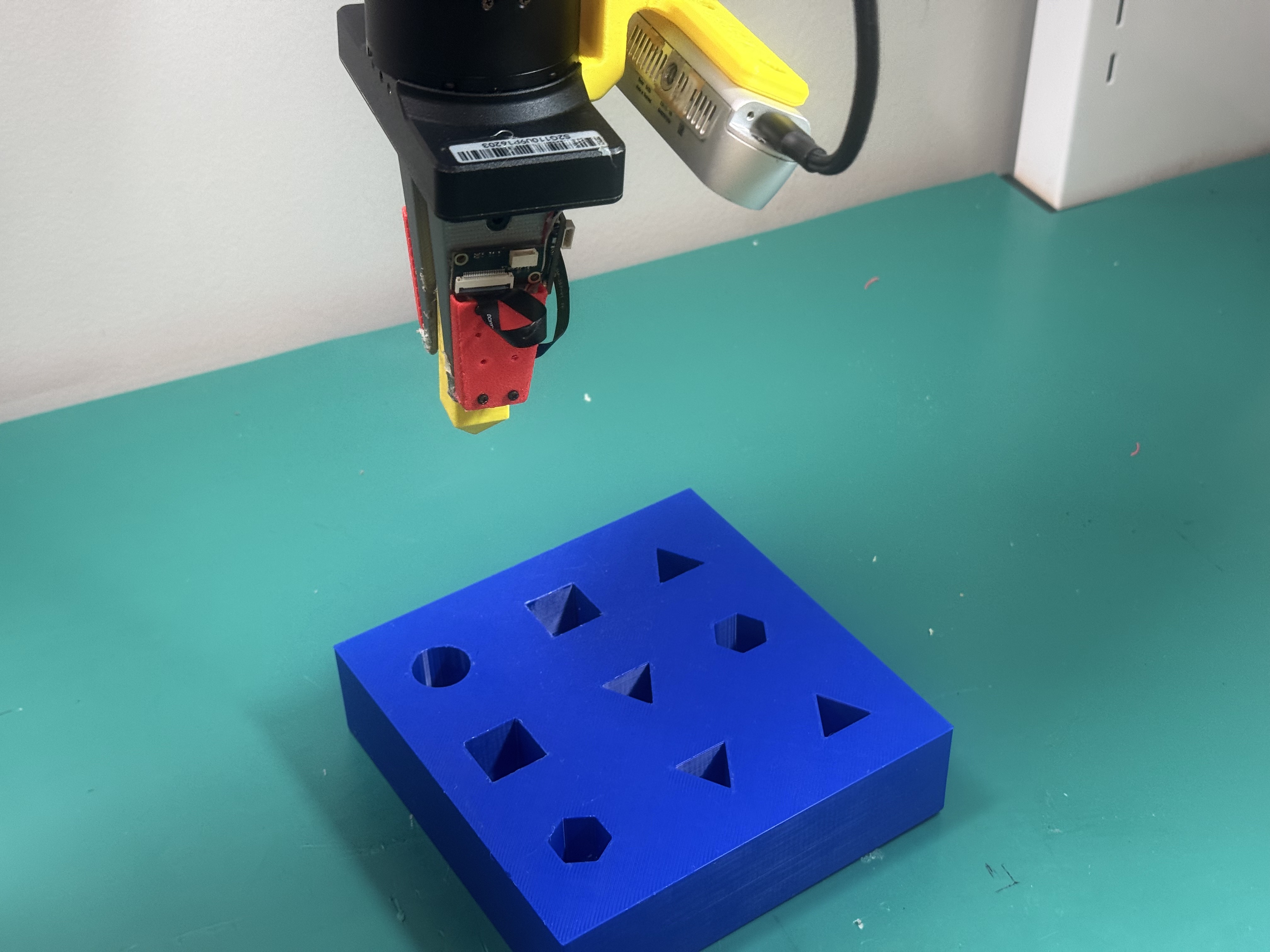 Robot aligning a block with an insertion slot.
